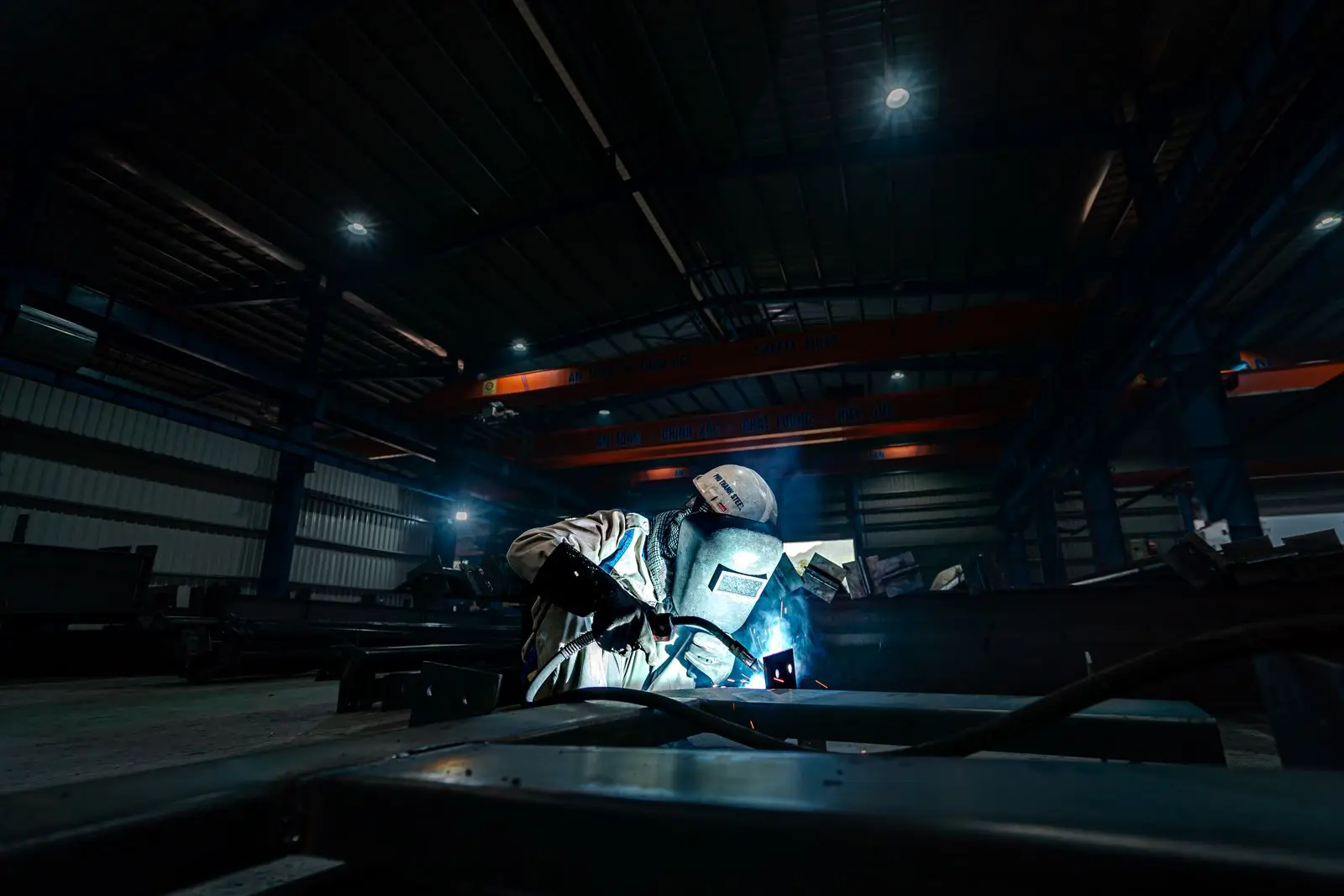 Technician working in a dimly lit workshop bay